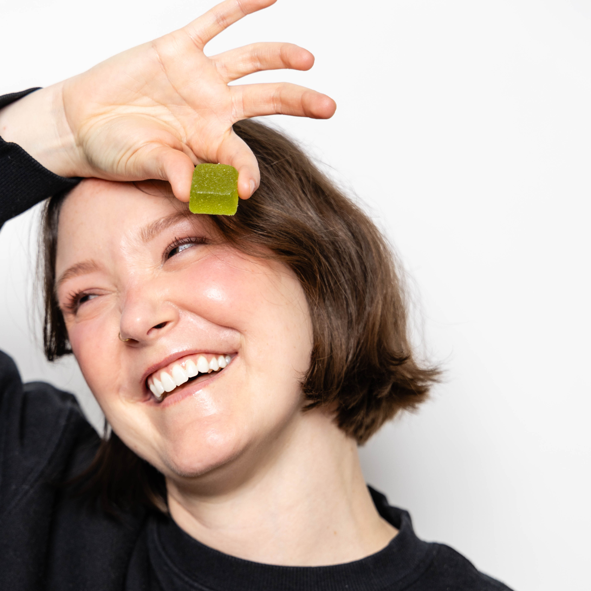 woman holding a live rosin sour green apple gummy