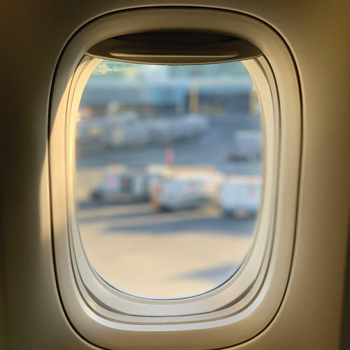 View through a window inside of an airplane - Can you fly with cannabis? Everything you need to know about traveling with THC