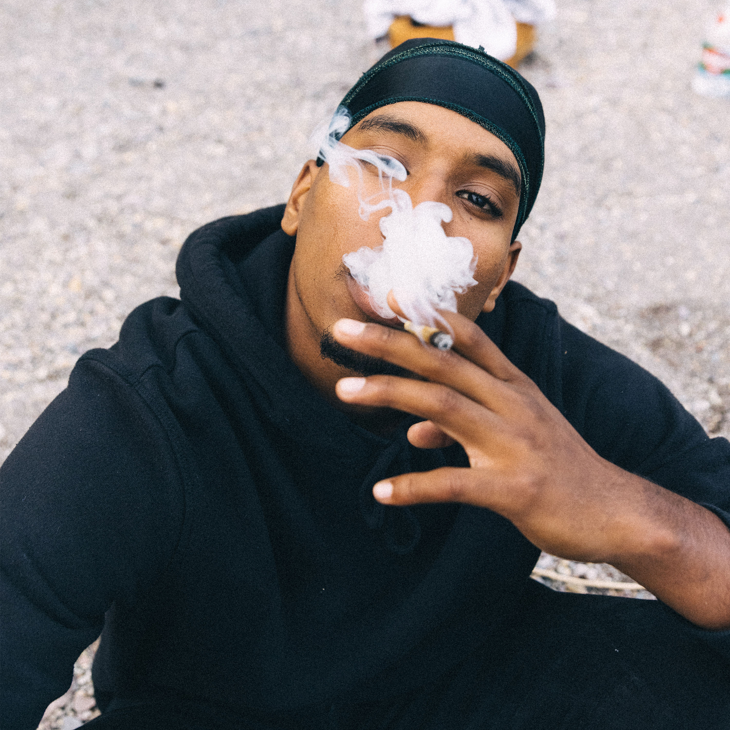 Person smoking a cannabis joint outdoors, illustrating how THCa flower converts into THC when heated through smoking.