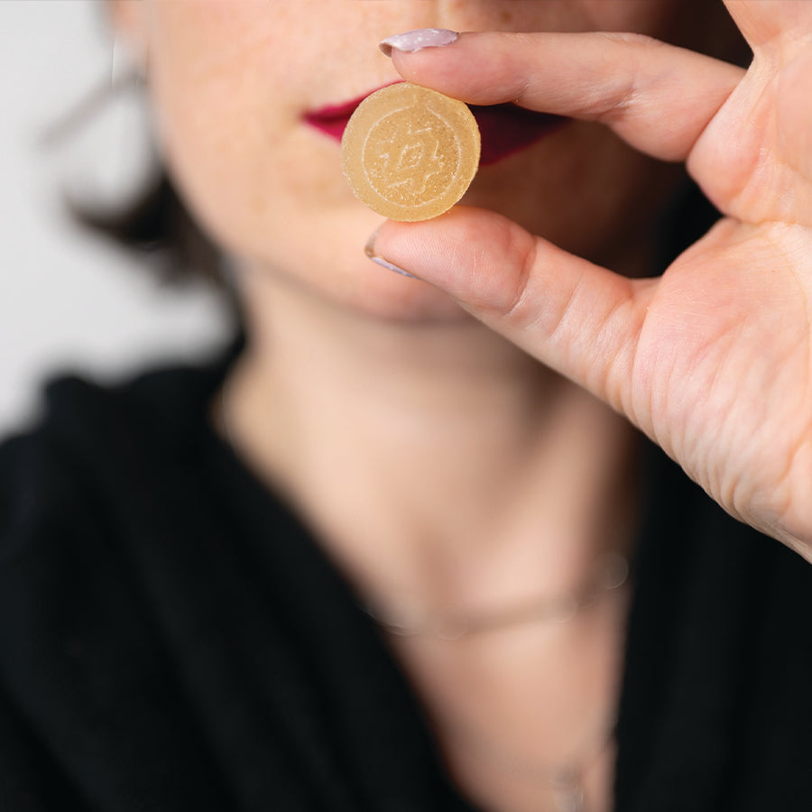 Person holding a cannabis gummy between fingers, highlighting edible dosing and THC gummies for beginners