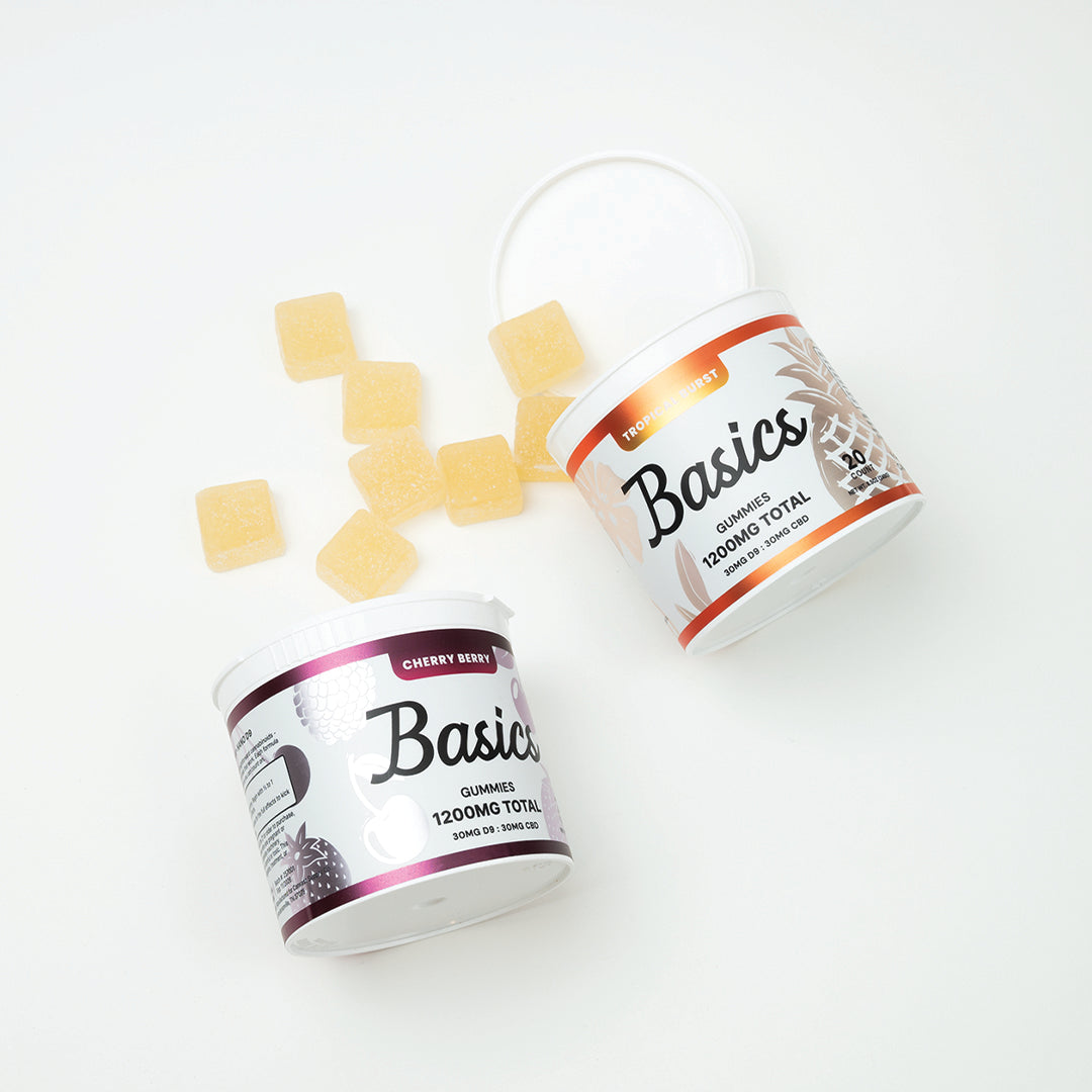 Two containers of 'Basics' gummies with cherry berry and tropical burst flavor on a white background. 1200mg total cannabinoids. 30mg Nano D9 THC + 30mg CBD.